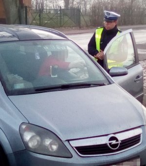 Policjant ruchu drogowego podczas kontroli pojazdu.