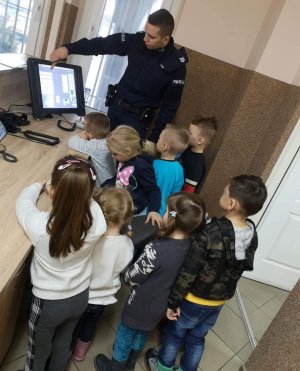 Dzieci oglądają konsolę służącą do przyjęcia zgłoszenia o interwencji oraz nawiązywania kontaktu z innymi jednostkami policji i obywatelami.