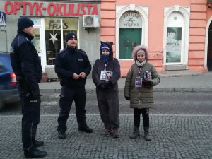 Policjanci podczas zabezpieczenia WOŚP. Z lewej strony na ul. Kościuszki stoi dwóch dzielnicowych, a w ich towarzystwie dwie wolontariuszki.