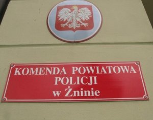 Godło, a pod nim czerwona tabliczka z napisem Komenda Powiatowa Policji w Żninie