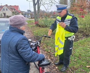 policjant  wręcza kamizelkę rowerzystce